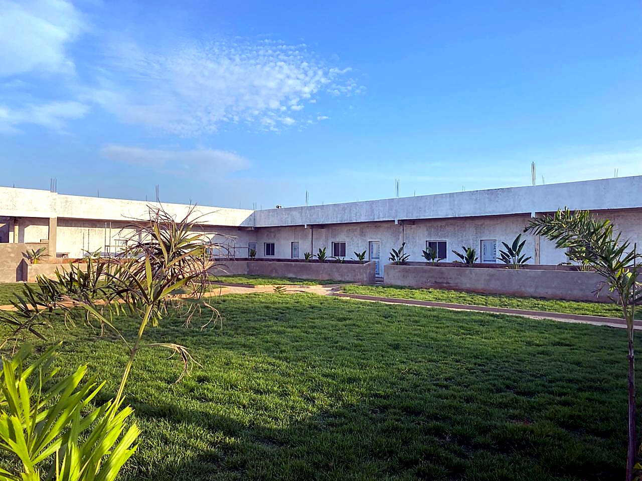 Edifício concluído com jardim e relva em frente