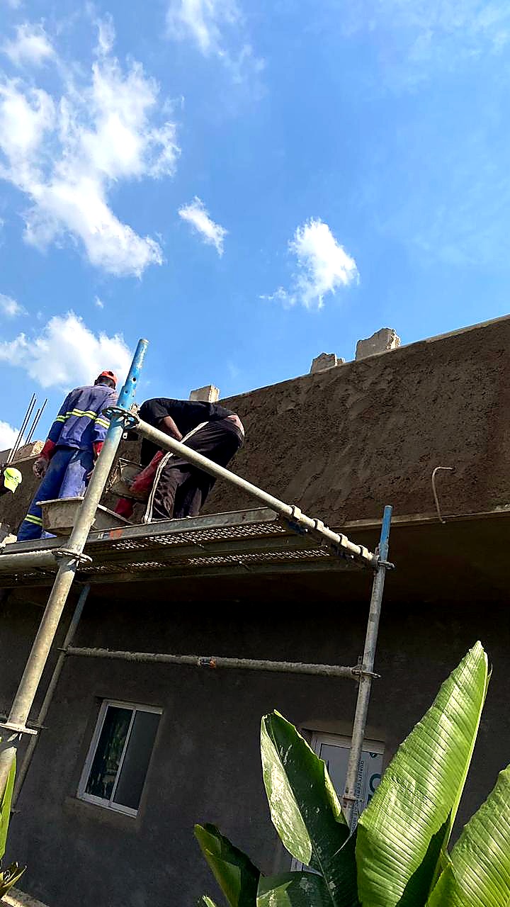 Aplicação de reboco e revestimento em fachada com andaime